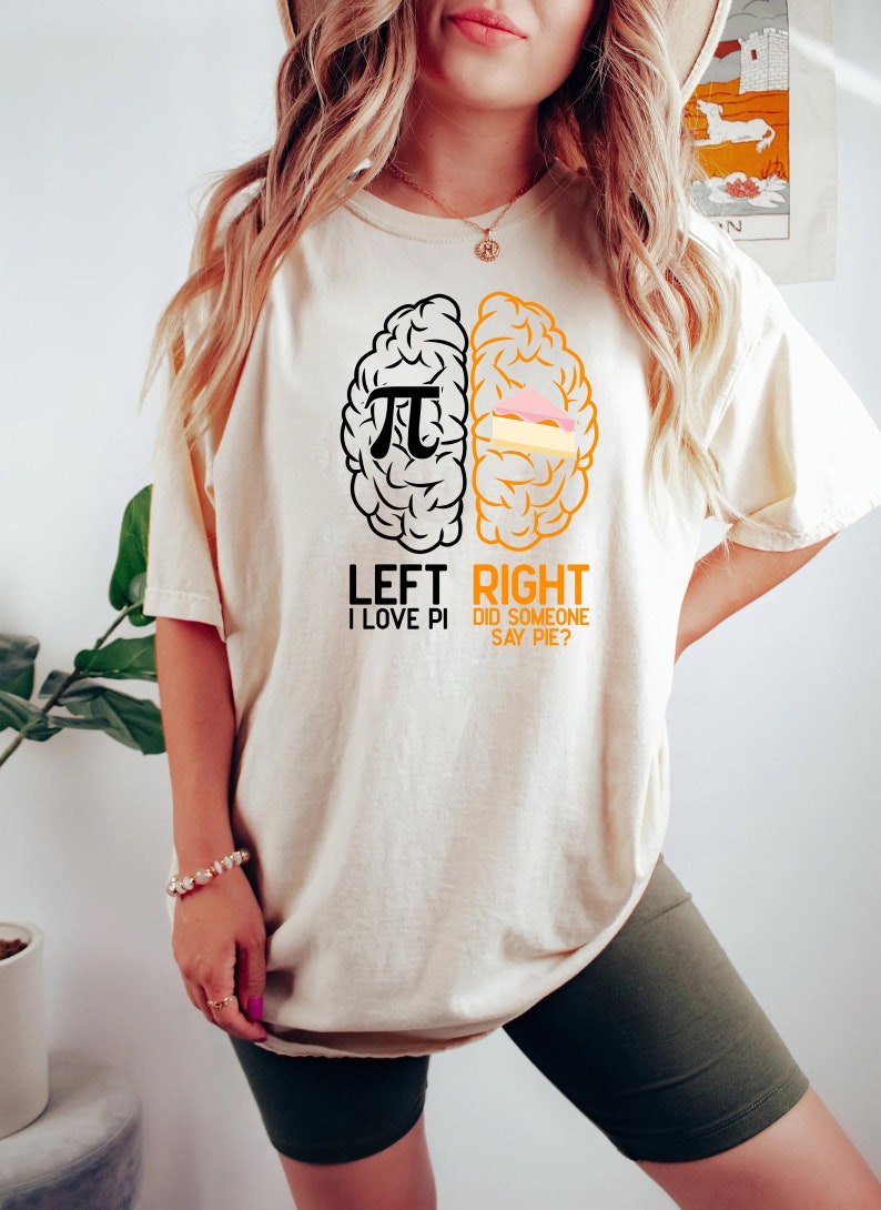 May include: A white t-shirt with a black and orange brain graphic. The left side of the brain has a pi symbol and the text "LEFT I LOVE PI". The right side of the brain has a slice of pie and the text "RIGHT DID SOMEONE SAY PIE?"