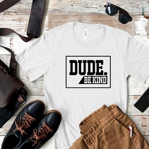 May include: White t-shirt with black text that reads "DUDE. BE KIND" in a box.