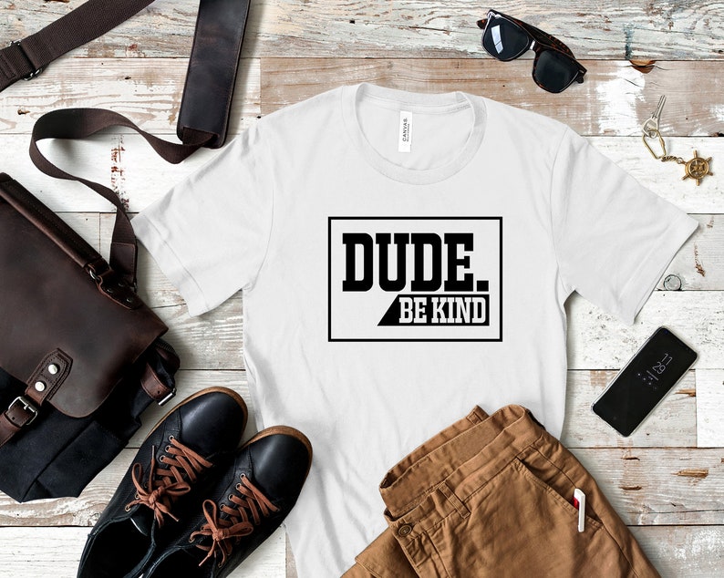 May include: White t-shirt with black text that reads "DUDE. BE KIND" in a box.