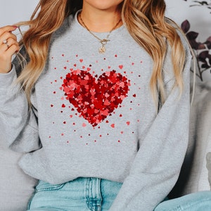 May include: A gray sweatshirt with a red heart made of smaller hearts printed on the front.