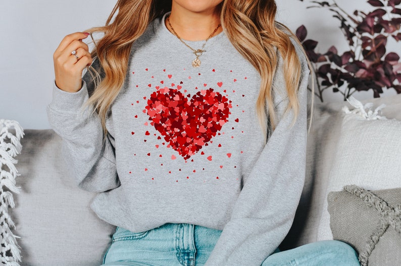 May include: A gray sweatshirt with a red heart made of smaller hearts printed on the front.