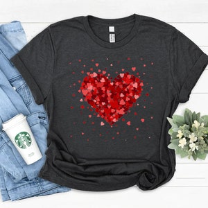 May include: A dark gray t-shirt with a red heart made of smaller red hearts. The heart is surrounded by smaller red hearts.