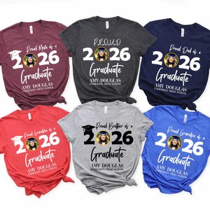May include: A collection of six short-sleeved t-shirts in various colors, each featuring a graduation-themed design. The shirts display the text "Proud Mom of a 2026 Graduate," "Proud Dad of a 2026 Graduate," and other family-related phrases.