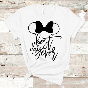 May include: White t-shirt with a black Mickey Mouse ears silhouette and the text "best day ever" in black script.