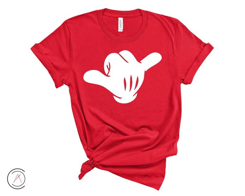 May include: Red t-shirt with a white hand making a shaka sign.