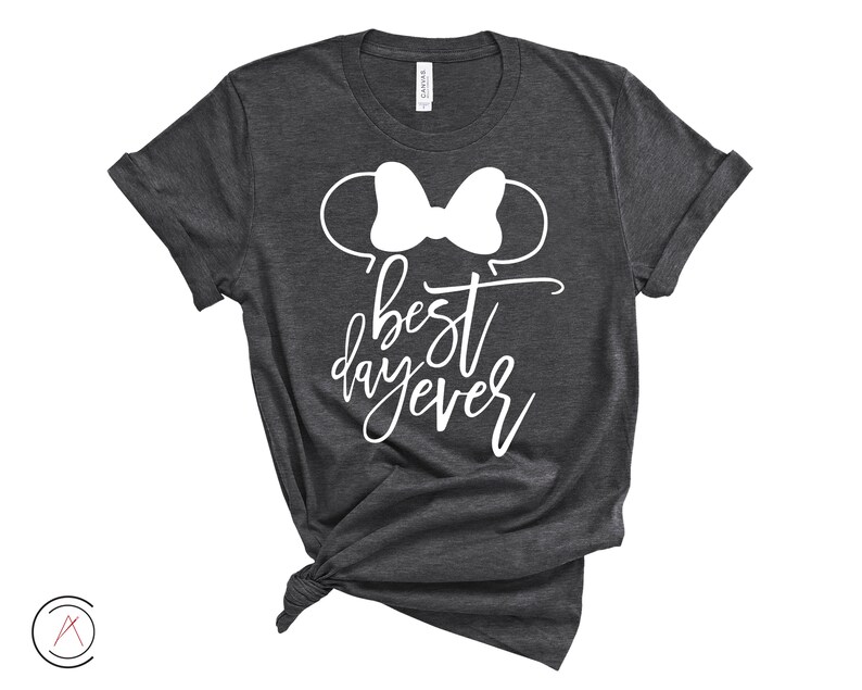 May include: A dark gray t-shirt with a white outline of Mickey Mouse ears and a bow. The text "best day ever" is written in white cursive lettering.