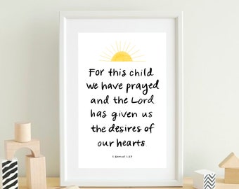 May include: A framed print with the text "For this child we have prayed and the Lord has given us the desires of our hearts." The print includes a yellow sun illustration and the Bible verse 1 Samuel 1:27. The frame is white.
