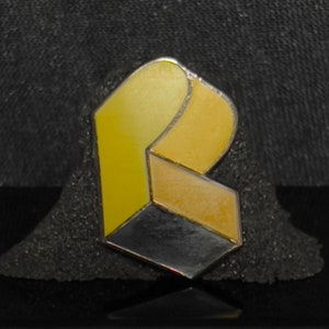 May include: A yellow and black geometric ring with a three-dimensional design.