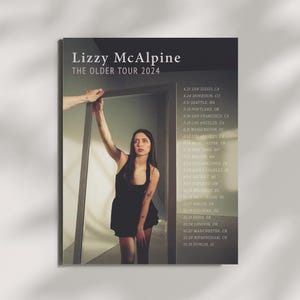 Peut inclure: Une affiche en noir et blanc annonçant une tournée de concerts pour la chanteuse-compositrice Lizzy McAlpine. L'affiche présente une photo de McAlpine devant un miroir, avec les dates et les villes de la tournée énumérées à droite. La tournée s'appelle "The Older Tour 2024".