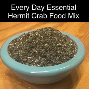 Puede incluir: Un taz&oacute;n azul lleno de una mezcla de comida gris oscuro y blanco etiquetada como "Every Day Essential Hermit Crab Food Mix".