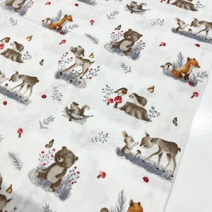 May include: White fabric featuring a repeating pattern of woodland creatures, including deer, squirrels, bears, foxes, and birds. The animals are depicted in a charming style with muted colours.
