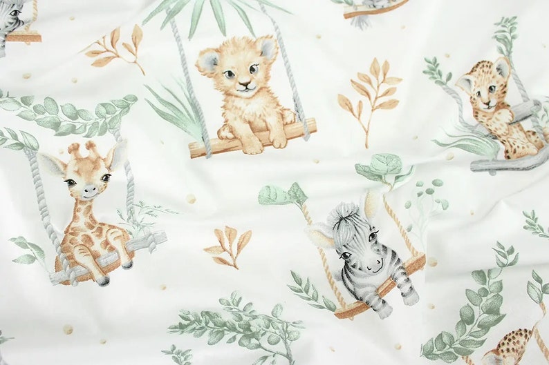 May include: White fabric with a repeating pattern of jungle animals on swings. The animals include a giraffe, a lion, a zebra, and a leopard. The animals are all in a cartoon style and are surrounded by green leaves.
