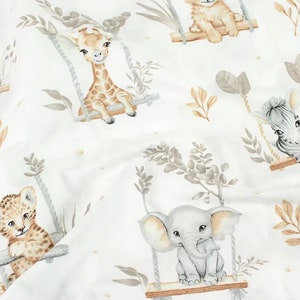 May include: A white fabric with a repeating pattern of various animals on swings. The animals include a giraffe, zebra, lion, and elephant. The animals are all depicted in a watercolor style and are surrounded by leaves and branches.