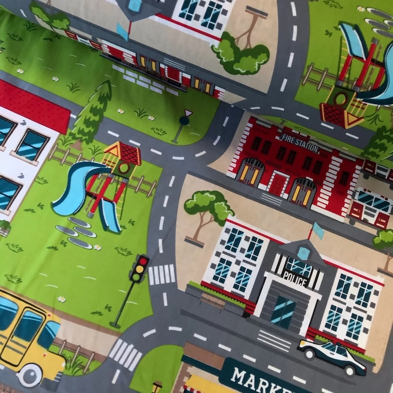 May include: A colorful play mat with a city theme. The mat features a fire station, police station, playground, and a school. The mat is made of a soft, durable material and is perfect for kids to play on.