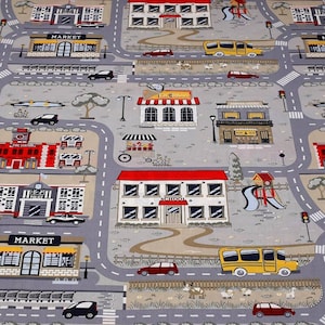 May include: A colorful play mat with a city theme. The mat features a school, a market, a coffee house, a fire station, and a police station. There are also cars, trucks, and people on the mat.