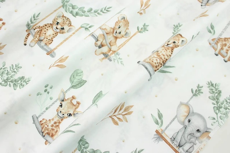 May include: White fabric with a repeating pattern of various animals on swings. The animals include a giraffe, a lion, a leopard, and an elephant. The animals are all in a cartoon style and are surrounded by green leaves and brown branches.