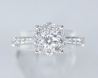 White gold entourage ring with large brilliant cut diamonds.
