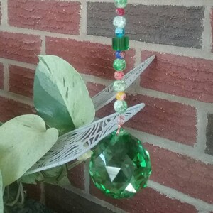 Green crystal ball prism with green cube beads, crackle  glass beads, and millefiore beads. A bright copper wire wrapped sun catcher!