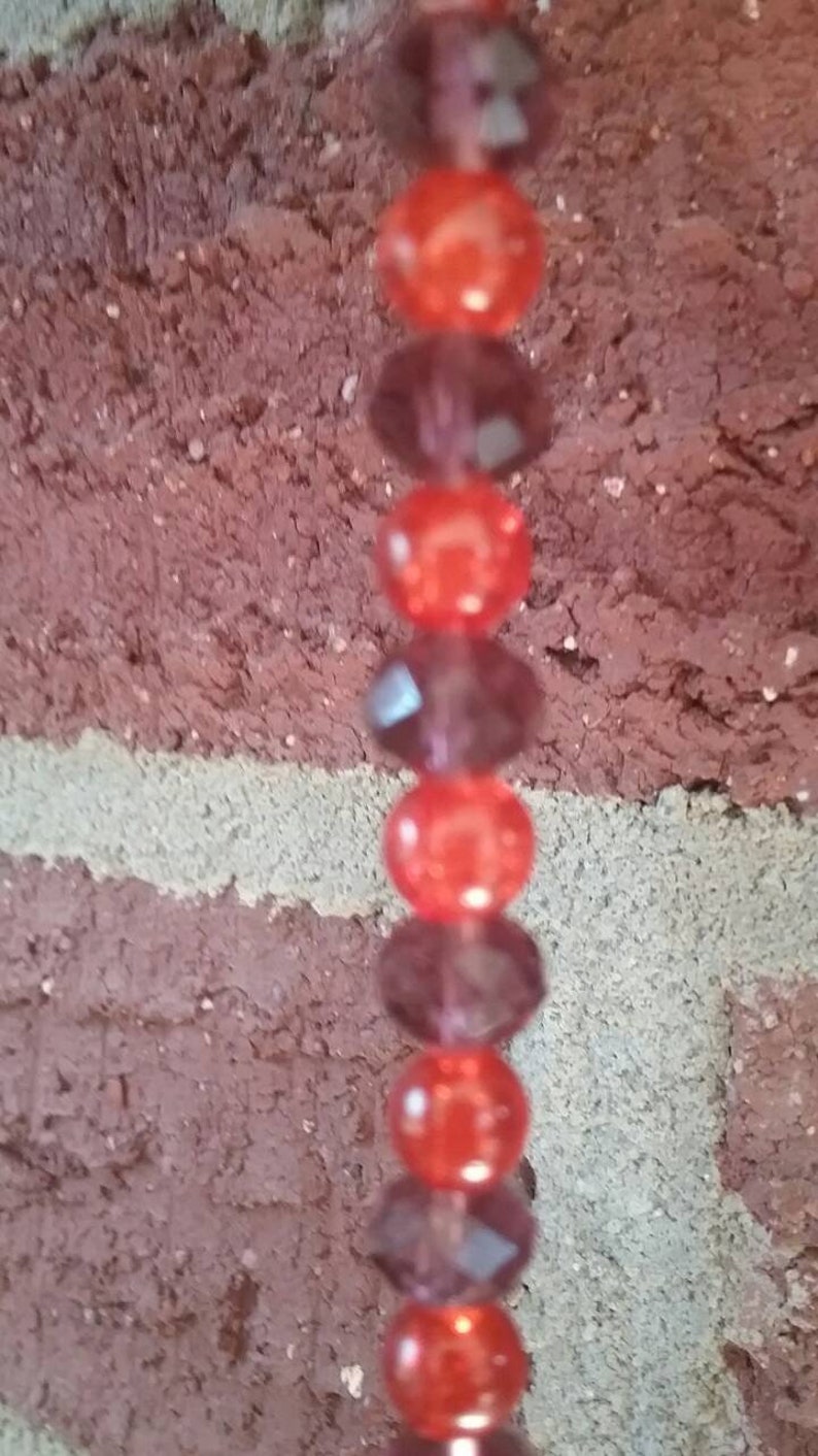 Orange /& maroon burgundy suncatcher with orange ball prism maroon and orange glass beads and a perfect center faceted orange glass gem!