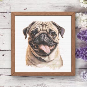 May include: A framed cross-stitch embroidery featuring a detailed portrait of a fawn-colored pug with a black muzzle, dark eyes, and a pink tongue hanging out. The dog is centered against a white background, enclosed in a light brown wooden frame.