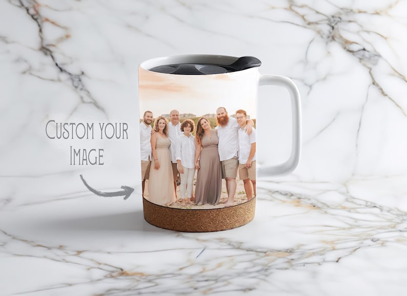May include: White travel mug with a cork bottom and a black lid. The mug has a photo of a family of seven standing on a beach at sunset.