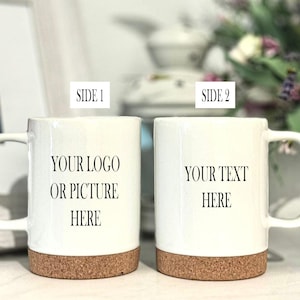 May include: Two white ceramic mugs with cork bottoms. The mug on the left has the text "YOUR LOGO OR PICTURE HERE" printed on it. The mug on the right has the text "YOUR TEXT HERE" printed on it.