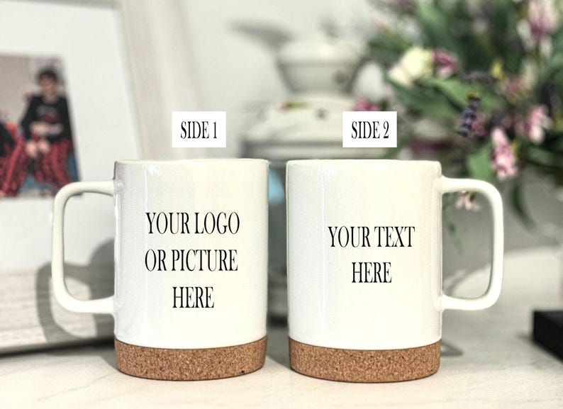 May include: Two white ceramic mugs with cork bottoms. The mug on the left has the text "YOUR LOGO OR PICTURE HERE" printed on it. The mug on the right has the text "YOUR TEXT HERE" printed on it.