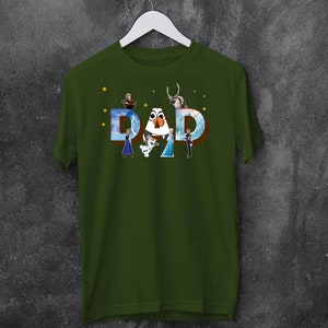 May include: Green t-shirt featuring a graphic of the characters from the film Frozen spelling out the word "DAD".