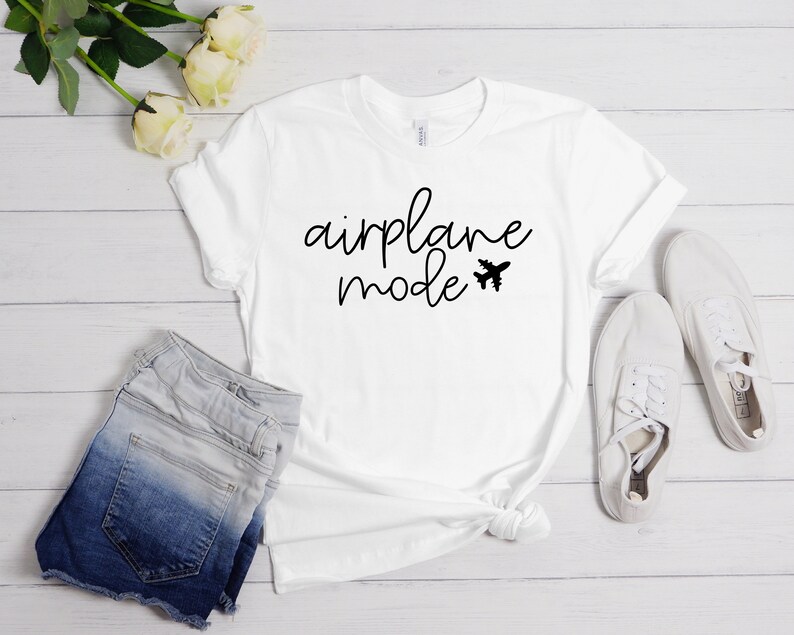 May include: White t-shirt with black text that says "airplane mode" and a small airplane graphic.
