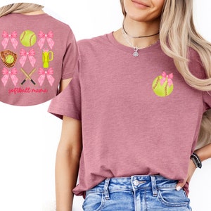 May include: A pink t-shirt with a softball and pink bows on the front and a softball, bows, bats, and a glove on the back. The text "softball mama" is on the back of the shirt.