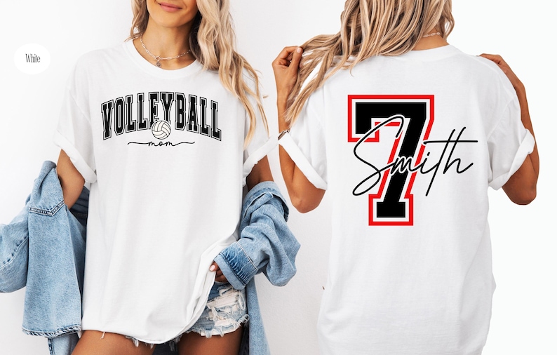 May include: Two white t-shirts, one with the text "VOLLEYBALL mom" and a volleyball graphic, and the other with a black number "7" and the text "Smith" in a red and black frame.