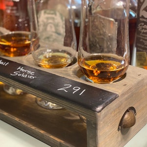 Handmade flight crate in classic gray shown being used with tasting glasses and whiskey tasting. Chalkboard design allows for easy drink labeling.