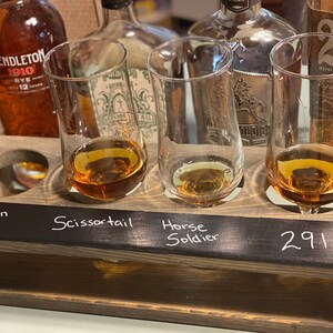 Handmade flight crate for tasting parties. Brass finger handle on each end and chalkboard for tasting labeling. shown with whiskey and tasting glasses.