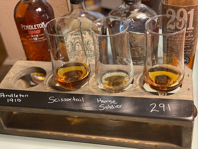 Handmade flight crate for tasting parties. Brass finger handle on each end and chalkboard for tasting labeling. shown with whiskey and tasting glasses.