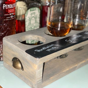 Handcrafted flight crate in classic gray finish. Crate designed for safe transport of flights and chalkboard for drink labeling. Shown with tasting glasses and whiskey.