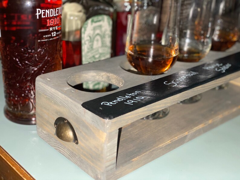 Handcrafted flight crate in classic gray finish. Crate designed for safe transport of flights and chalkboard for drink labeling. Shown with tasting glasses and whiskey.
