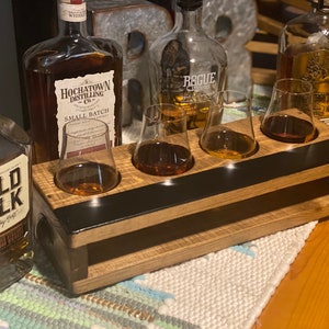 Handmade flight crate for tasting parties in special walnut finish. Crate design allows for secure drink placement and built in chalkboard design provides easy labeling for drinks. Shown with whiskey and Glencairn glasses.
