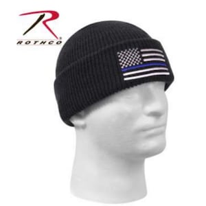 May include: Black knitted beanie with a thin blue line American flag patch.