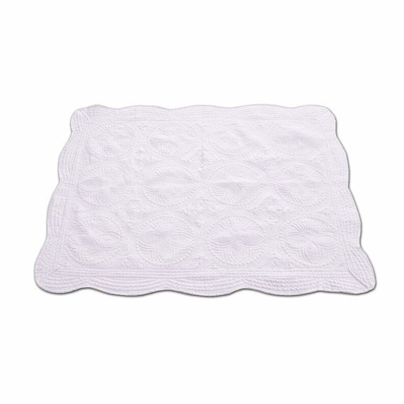 May include: White quilted throw blanket with a scalloped edge and a delicate floral pattern.