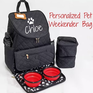 May include: Black quilted pet carrier backpack with a paw print and the name "Chloe" embroidered on the front. The backpack has two zippered compartments, a mesh pocket, and a removable, foldable food and water bowl set.