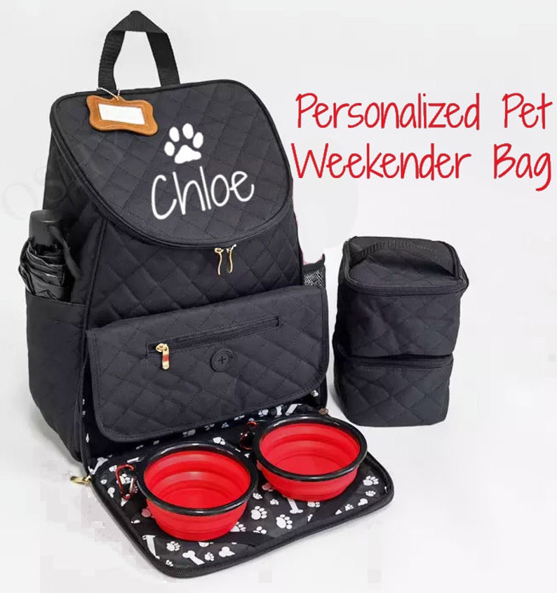 May include: Black quilted pet carrier backpack with a paw print and the name "Chloe" embroidered on the front. The backpack has two zippered compartments, a mesh pocket, and a removable, foldable food and water bowl set.