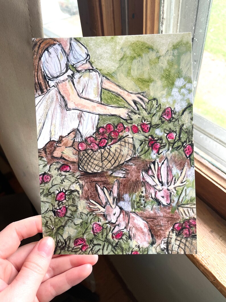 May include: Two figures in white dresses are picking strawberries in a field. A basket of red strawberries sits on a wooden table. Three rabbits with antlers are eating strawberries in the field.