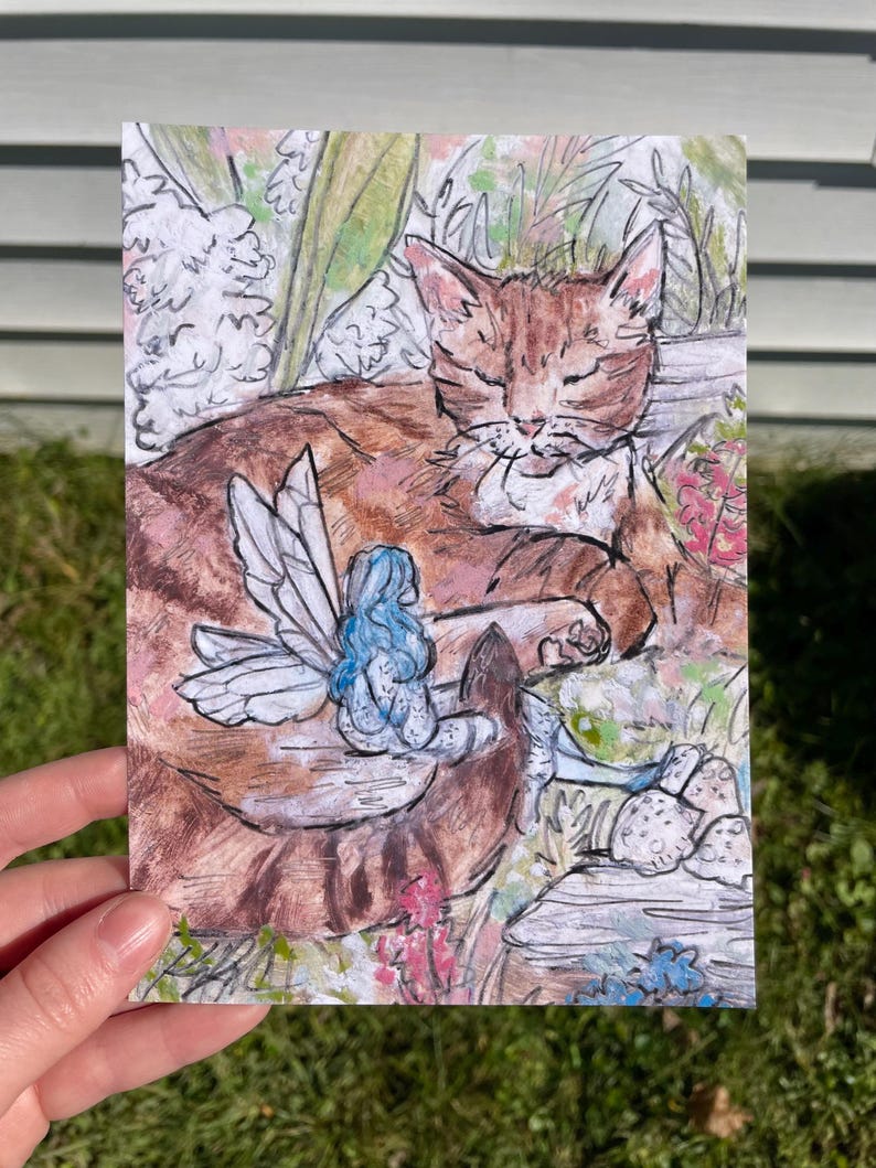 Puede incluir: Una ilustraci&oacute;n de acuarela de un gato atigrado marr&oacute;n durmiendo con un hada azul con alas blancas sentada sobre su espalda. El gato est&aacute; rodeado de follaje verde y flores rosas.