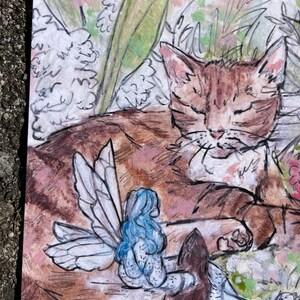 Puede incluir: Una pintura de acuarela de un gato atigrado marr&oacute;n durmiendo con un hada azul con alas sentada en un hongo. El gato est&aacute; rodeado de follaje verde y flores blancas.