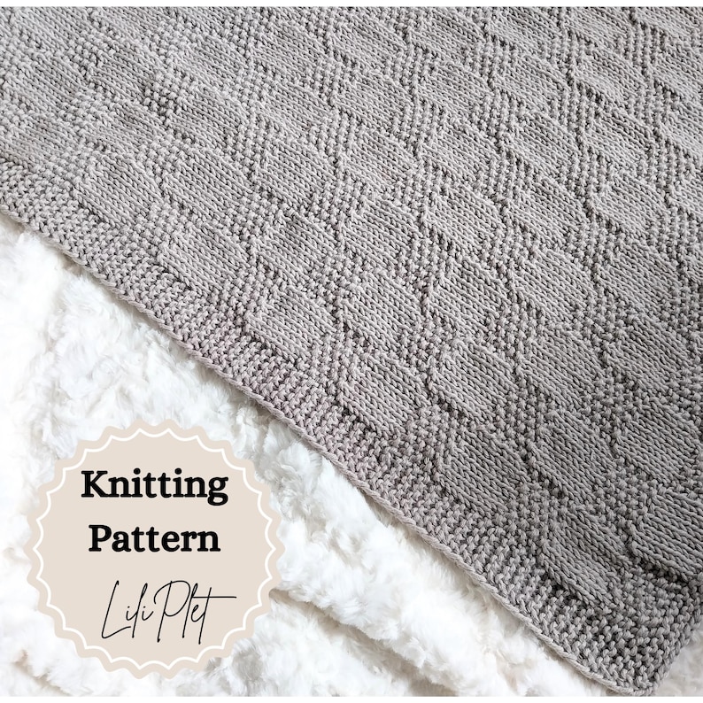 May include: A knitted blanket in a diamond pattern, in a soft gray color. The blanket is displayed on a white, fluffy surface. The text "Knitting Pattern" and "Lili Plet" are visible on the image.