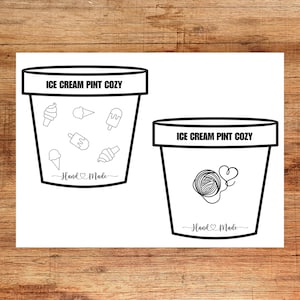 May include: Black and white line art illustration of two ice cream pint cozies. The cozies are shaped like ice cream containers with a rounded top and a straight bottom. The top of each cozy has the text "ICE CREAM PINT COZY" and the bottom has the text "Hand Made". The cozy on the left has a variety of ice cream cone and popsicle designs. The cozy on the right has a ball of yarn with a heart attached to it.