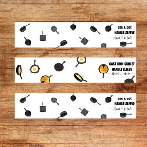 May include: Three white labels with a pattern of black cast iron cookware, including skillets, pots, and a grill. The labels have text that reads "pan & pot HANDLE SLEEVE Hand Made" and "CAST IRON SKILLET HANDLE SLEEVE Hand Made".