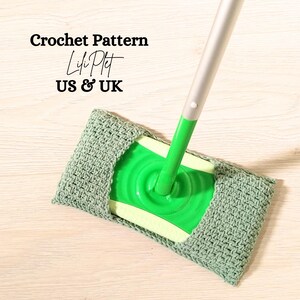 Könnte beinhalten: Ein grüner Häkel-Moppkopf mit einem silbernen Stiel. Der Moppkopf ist in einfacher Masche gehäkelt und hat eine grüne und weiße Plastikbasis. Der Text "Crochet Pattern Lifi Plit US & UK" ist im Bild sichtbar.