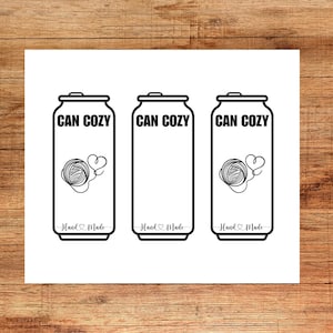 May include: Three white can cozies with black outlines and text. Each cozy has the words "CAN COZY" at the top and "Hand Made" at the bottom. One cozy has a yarn ball and heart design.