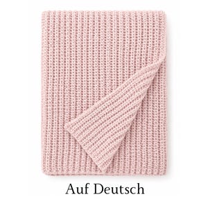 May include: A soft, light pink knitted blanket featuring a prominent vertical ribbed texture. The blanket is folded over at the top right corner, revealing the consistent knit pattern and the solid, muted pastel color throughout the entire piece.